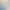 Eine unscharfe Person geht durch einen Flur, der mit zwei Bildern und einem weißen Möbelstück mit Gegenständen darauf dekoriert ist.